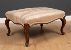 A continental style walnut rectangular stool with overstuffed upholstered seat and carved cabriole