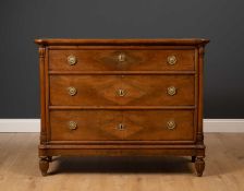 A late 19th or early 20th century French walnut three drawer commode, with outset pilaster columns