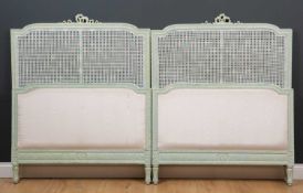 A pair of green painted single beds with caned inset panelsCondition report: One inner caned panel