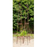 A pair of wrought iron garden stands or obelisks of triangular section with scroll tops, each