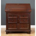 A William and Mary oak bureau, the fall front enclosing a fitted interior with pigeon holes and