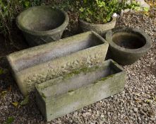 Two cast reconstituted stone troughs or planters together with three further planters, the largest
