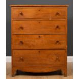 An early 19th century elm chest of four long graduated drawers with turned lignum vitae handles