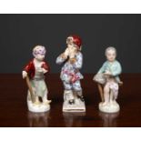 A group of three Berlin porcelain figures of boys one representing Winter, the other two curiously