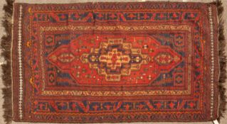 A mid to late 20th century Eastern blue and red ground rug with a banded border and geometric