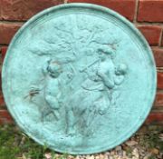 A green painted cast concrete roundel depicting a classical maiden playing pipes for a fawn, 50cm