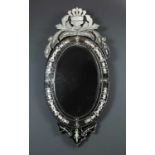 A contemporary Venetian style oval wall mirror with decorative crest, the mirror with engraved slips
