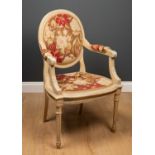 A painted French style armchair with needlework upholstery and turned tapering fluted legs, 57cm