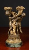 An antique French parcel-gilt bronze candelabrum with cherub supports and on a marble socle, 29cm