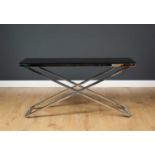 A contemporary chrome plated X framed console table with black glass top, 134cm wide x 40cm deep x