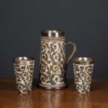 A Doulton stoneware silver mounted ale jug together with a pair of matching beakers, each