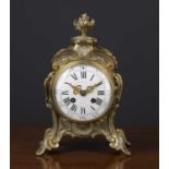 A 19th century French rococo style cast brass mantle timepiece, the enamel roman dial indistinctly