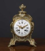 A 19th century French rococo style cast brass mantle timepiece, the enamel roman dial indistinctly