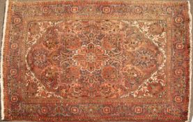 A late 20th century Middle Eastern red ground rug with a banded border, geometric foliate