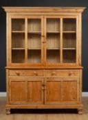 A pine dresser, the glazed upper section enclosing two shelves above a base with two drawers and two