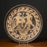 A terracotta dish with classical ornament in the Etruscan style, 40cm diameter bearing a possibly