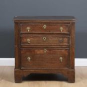 An 18th century and later small size chest of three drawers with panelled sides, later drop
