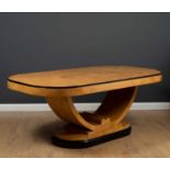 An art deco style burr maple wood veneered dining table with rounded ends, the U shaped support on