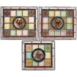 A near pair of antique leaded stained glass panels with circular central plates hand painted with