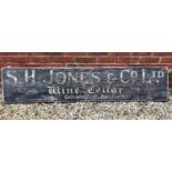 A painted sign for SH Jones & Co Limited Wine Cellar, the sign painted on a pine board, 171cm wide x