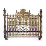 A Victorian brass bedstead in the aesthetic style, decorated with stylised floral roundels and fans,