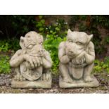 A pair of weathered cast reconstituted stone gate post finials in the form of squat mythical