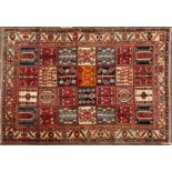A Persian style rug the central field with twenty eight squares within a multiple banded border,
