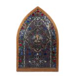 A 19th century or earlier stained glass window of gothic arched form, with stylised leaves and
