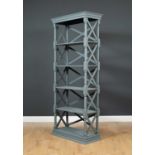 A contemporary five tier whatnot or set of shelves painted in grey with X supports to the sides