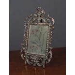 A continental cast metal framed dressing table mirror with pierced scrolling frame and shell and