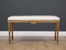 A late 19th or early 20th century rectangular gilt window seat with silk upholstery and standing