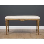 A late 19th or early 20th century rectangular gilt window seat with silk upholstery and standing