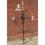 A wrought iron weathervane with unicorn vane, scrolling ornament and bracket for wall mounting,