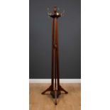 An Edwardian walnut coat stand with turned finial, brass hooks and spreading reeded legs, 194cm
