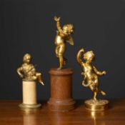A gilt bronze sculpture of a cherub later mounted on an oak socle, together with a gilt metal