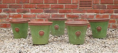 A set of five green glazed terracotta circular tapering planters each decorated with a roundel, 28.
