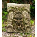 A weathered reconstituted stone plaque for wall mounting of a green man, 42cm wide x 53cm