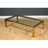 A brass rectangular coffee table with glass inset top and standing on square legs, 37.2cm long x