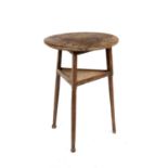 An antique oak circular small size occasional cricket table the turned legs united by an