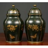A pair of dark green ground papier mache jars and covers with gilt decoration of butterflies and
