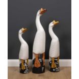 A graduated set of three painted carved wooden sculptures of geese, the largest 99cm highCondition