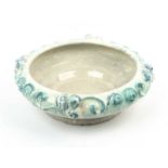 An early 20th century Swedish pottery tin glazed bowl with moulded glazed fruiting decoration to the
