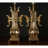 A brass Chinese style table lamps of archaic form on wooden bases, 67cm high to the light