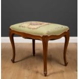A contemporary hardwood stool in the 18th century French style, with needlework upholstered seat and