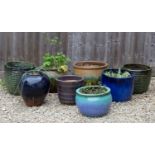 A pair of green glazed ribbed circular garden planters together with six further planters, the green