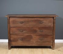 A 19th century French oak three drawer commode, the three drawers flanked by pilaster columns and