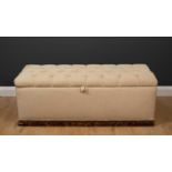 An old upholstered ottoman stool with carrying handles to the ends and button upholstered lid, 125cm