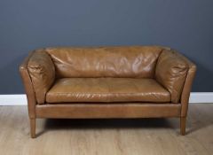 A contemporary tan leather upholstered two seater sofa on square legs, 149cm wide x 80cm deep x 70cm