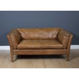 A contemporary tan leather upholstered two seater sofa on square legs, 149cm wide x 80cm deep x 70cm
