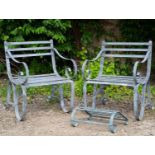 A pair of galvanized wrought iron armchairs with scrolling supports, each chair 63cm wide x 83.5cm